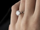 a close up of a person ' s hand holding a diamond ring