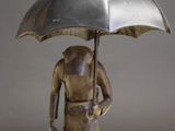 a statue of a woman holding an umbrella on a table