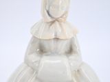 a figurine of a woman in a white dress