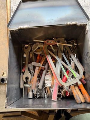 Caisse à outils artisanale en métal composée d'outils, clés, pinces,