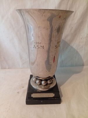 un vase en argent posé sur un socle noir
