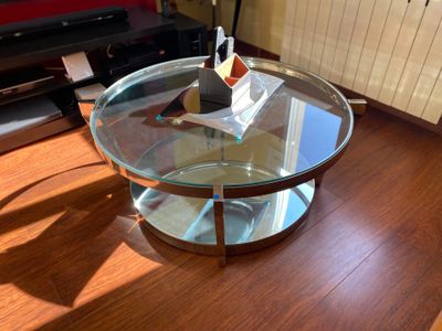 a glass coffee table with a glass top on a wooden floor