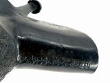 a black pipe that is sitting on a white surface
