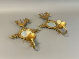 two gold colored candlesticks with birds on them
