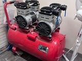 two air compressors sitting on top of a red cart