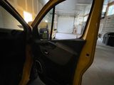 a yellow car with its door open in a garage