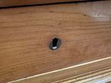 a small hole in the top of a wooden dresser