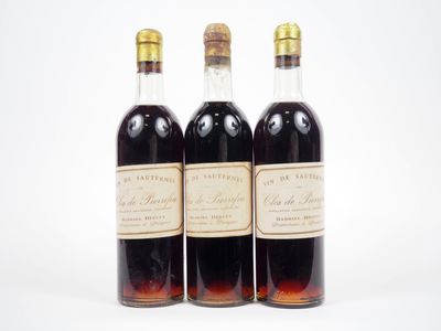 trois bouteilles de vin posées les unes à côté des autres sur une surface blanche