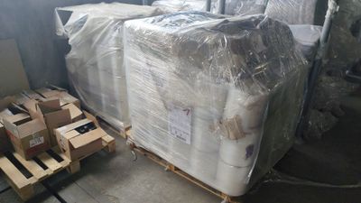 une palette remplie de cartons de matelas dans un entrepôt