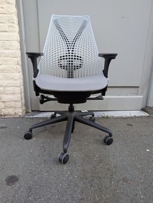 an office chair with a seat that has a black base and a white mesh back