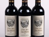 trois bouteilles de vin rouge posées sur une table blanche
