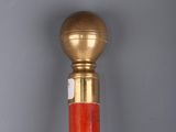 an image of a red and gold cane with a gold ball on top