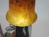 a person holding a cell phone with a lamp on top of it
