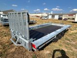 a trailer with a flat bed in the middle of a field