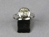 a close up of a ring with a diamond on a black surface