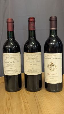 three bottles of wine are lined up on a wooden table