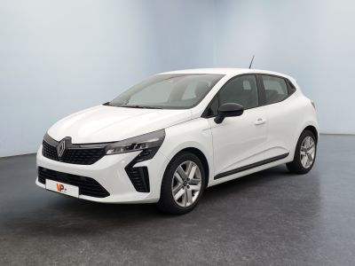 Une voiture blanche est garée dans une pièce au sol noir.