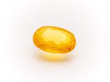 a yellow sapphire stone on a white background
