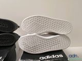 two pairs of adidas shoes sitting on top of a box