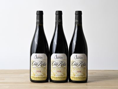 trois bouteilles de vin posées sur une table en bois