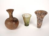 trois vases posés l'un à côté de l'autre sur une surface blanche