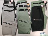 three pairs of men ' s pants are lined up on a table