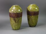 two vases sitting side by side on a gray surface