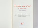 an open book with red writing on it sitting on top of a table