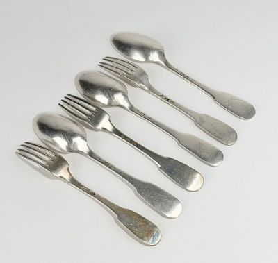 six fourchettes et cuillères sont disposées en ligne sur une surface blanche