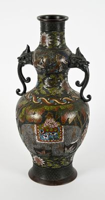 un vase noir orné d'un motif, posé sur une table