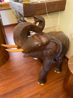 a statue of an elephant that is standing on a wooden floor