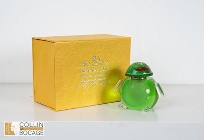 un petit vase en verre vert posé à côté d'une boîte jaune