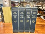 three books are sitting on a wooden table in a room