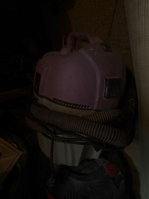un sèche-cheveux rose posé sur une pile de bagages