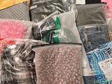 many different types of clothing in bags on the floor