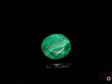 a close up of a green stone on a black surface