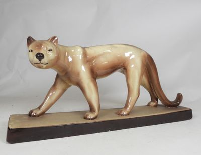 a figurine of a cat that is standing on a base