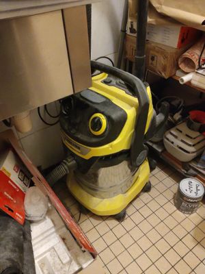 un aspirateur jaune et noir posé par terre dans une cuisine
