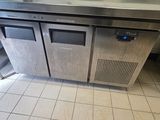 a stainless steel counter with two doors and a sink