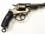 un vieux pistolet avec une crosse noire sur un fond blanc