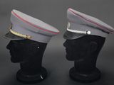pair of military hats on mannequin heads on a black background