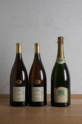 three bottles of wine are lined up on a wooden table