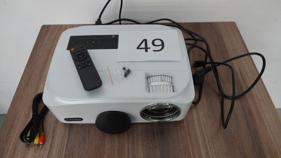 un petit projecteur avec une télécommande posé sur une table en bois