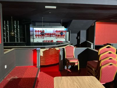 many chairs and tables in a room with a big screen