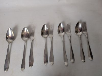 six spoons and six spoons sitting on a table