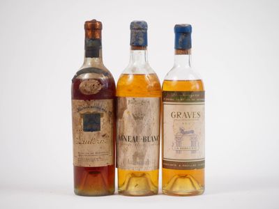 trois bouteilles de vin sont alignées sur une surface blanche