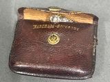 a brown leather wallet with a wooden handle on a table
