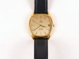 an image of a gold watch with a black strap on a white background