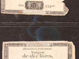 two old bank notes on display in a glass case