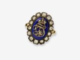 gros plan d'une bague en or avec une pierre bleue et des diamants